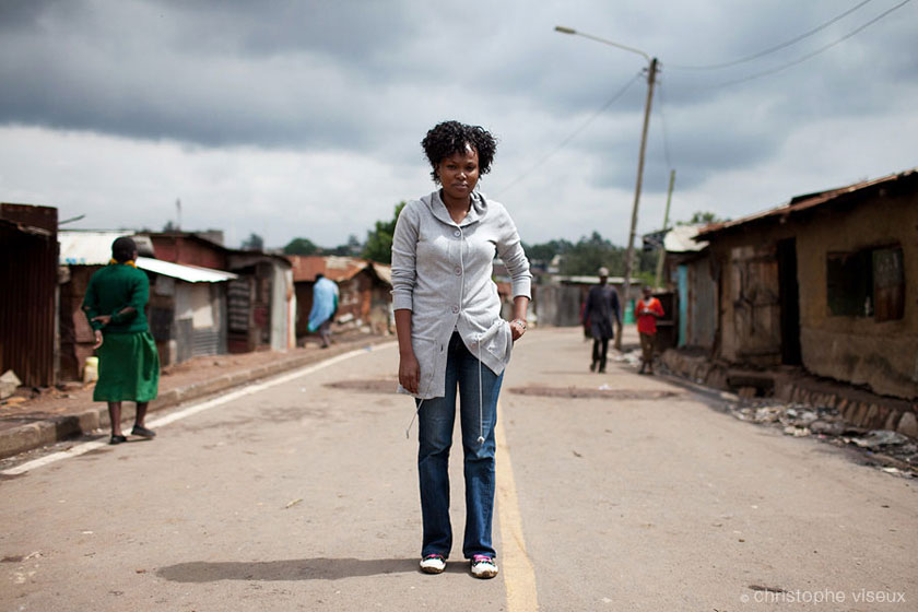 the journalist 'Chiku' is taking the pose on a street of one of largest slum in Nairobi: Korogocho