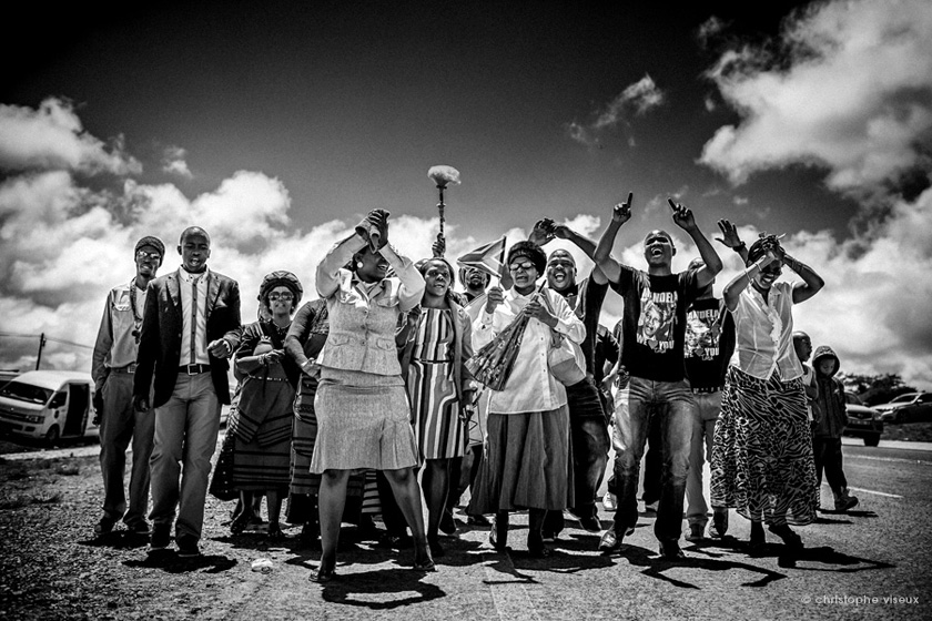 Group of villagers singind and dancing while Mandela is buried in his homeplace