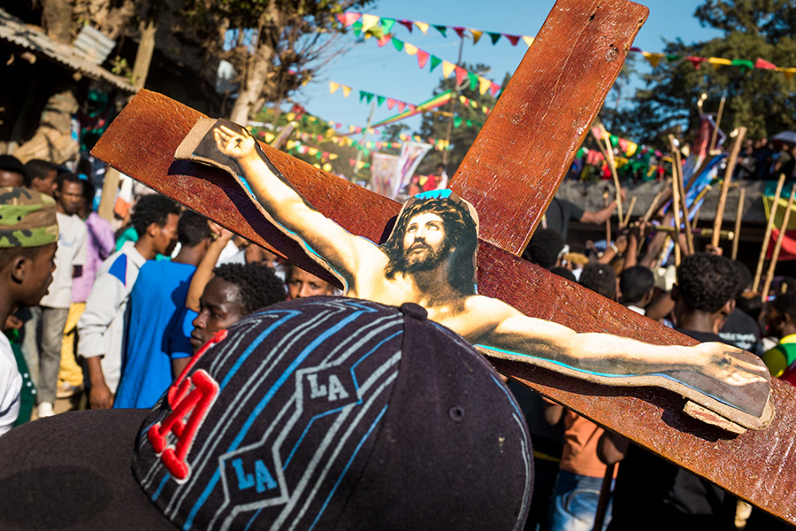 Timkat Gondar. A group leader is holding a Christian cross during the street procession of Timkat in Gondar